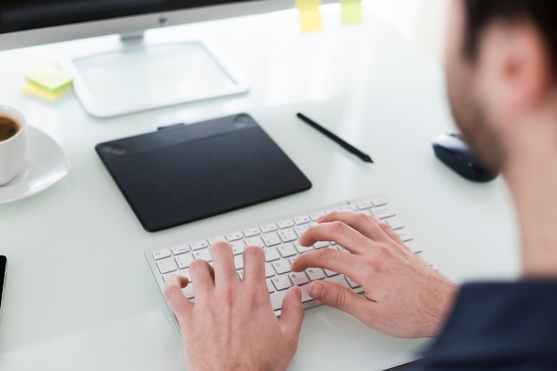 Cultivo hombre escribiendo en el teclado de la computadora