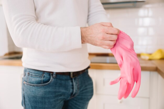 Cultivo hombre poniéndose guantes de goma