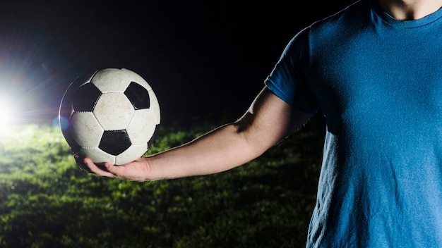 Foto gratuita cultivo hombre sosteniendo el balón de fútbol