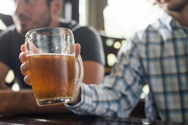 Cultivo hombre sosteniendo cerveza en la barra