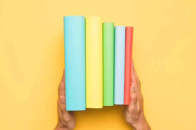 Cultivo hombre sosteniendo ordenado conjunto de libros