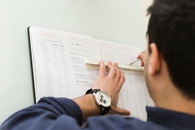 Foto gratuita cultivo hombre subrayando datos en el cuaderno