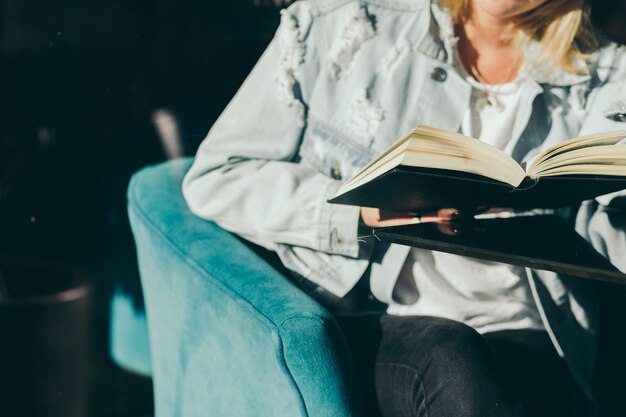 Cultivo de mujer disfrutando de libro en café