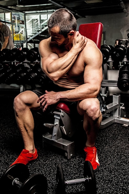 Culturista calentando antes de entrenar en un gimnasio.