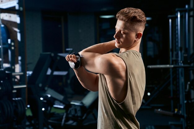 Culturista estirando los brazos en el gimnasio