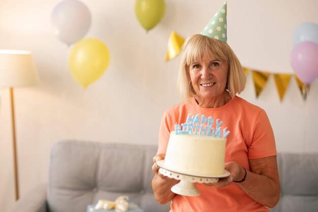 Cumpleaños de mujer mayor de plano medio.