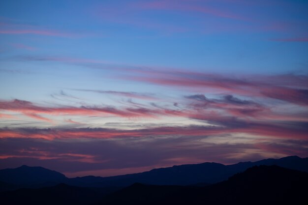 Cúmulos al atardecer con puesta de sol sobre fondo oscuro