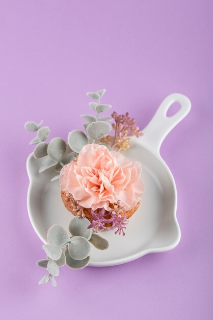 Cupcake de alto ángulo con flores y hojas.