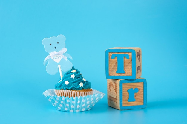 Foto gratuita cupcake azul para baby shower sobre fondo azul.