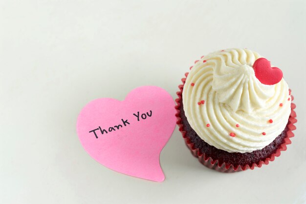 Cupcake con corazón rojo y gracias a masajear