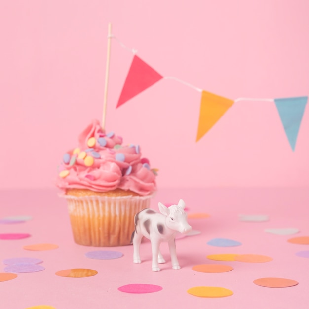 Cupcake de cumpleaños rosa con figura de vaca