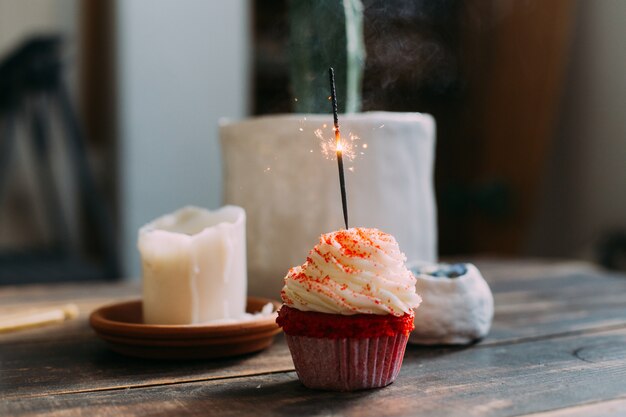 Cupcake de cumpleaños rosa con vela brillante