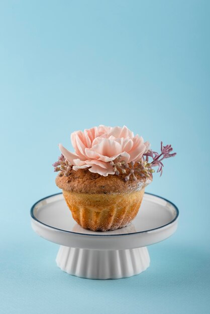 Cupcake con flor y fondo azul.