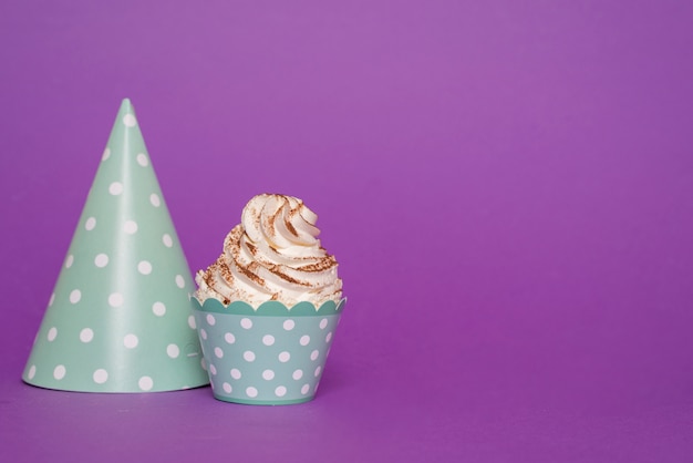 Foto gratuita cupcake junto a sombrero de papel