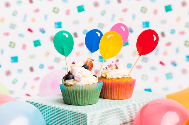 Cupcakes con adornos de globos en caja azul