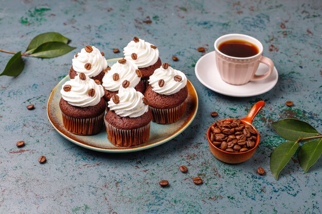 Cupcakes de café decorados con crema batida y granos de café.