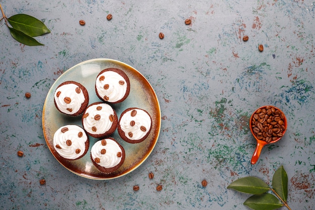 Cupcakes de café decorados con crema batida y granos de café.
