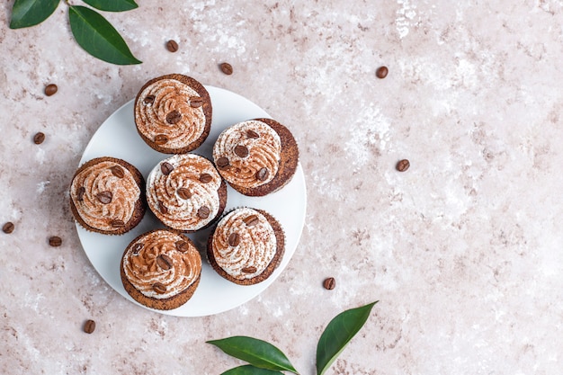 Cupcakes de café decorados con crema batida y granos de café.