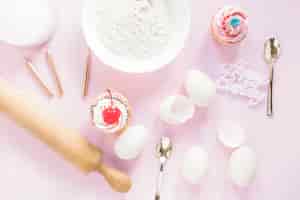Foto gratuita cupcakes cerca de los ingredientes de la torta de cumpleaños
