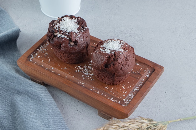 Cupcakes de chocolate en un tablero sobre fondo de mármol.