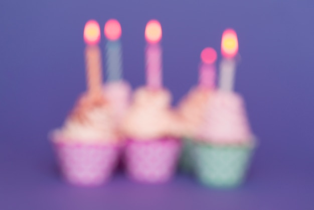 Cupcakes de cumpleaños borrosos con velas encendidas