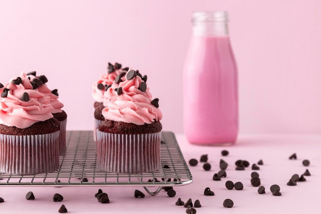 Foto gratuita cupcakes con glaseado rosa y bebida rosa