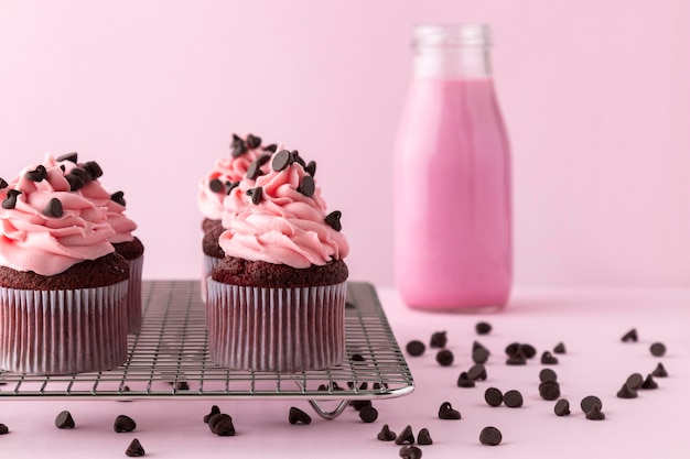 Cupcakes con glaseado rosa y bebida rosa
