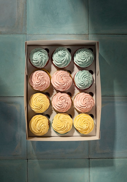 Foto gratuita cupcakes laicos planos en caja