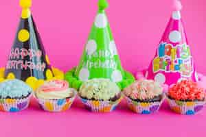 Foto gratuita cupcakes y sombreros de fiesta en rosa