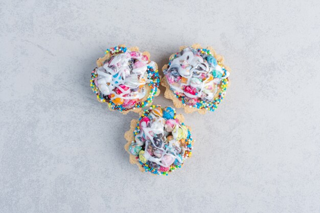 Cupcakes con toppings de caramelo agrupados sobre superficie de mármol