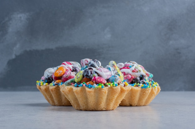 Cupcakes con toppings de caramelo agrupados sobre superficie de mármol