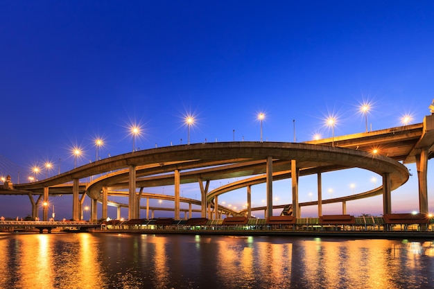 Curva de autopista por río en Bangkok al atardecer