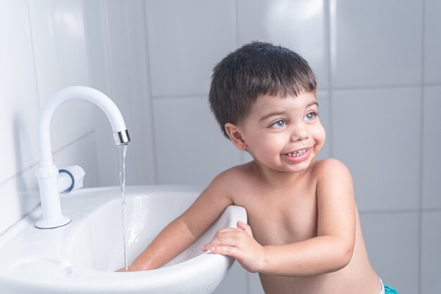 Cute Little Baby Boy lavarse las manos en el lavabo del baño