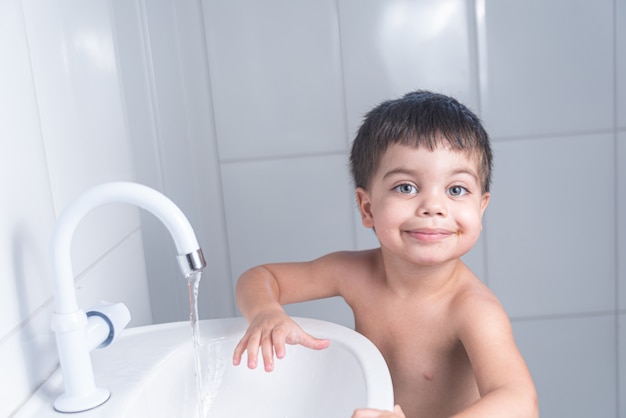 Cute Little Baby Boy lavarse las manos en el lavabo del baño