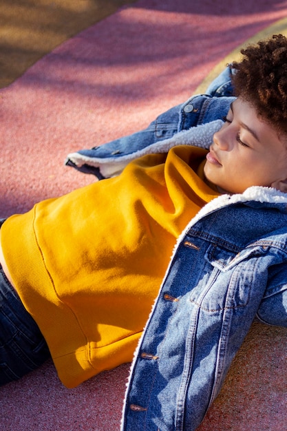 Cute little boy relajante en el patio de recreo