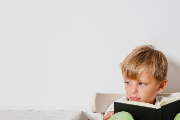 Cute niño sentado con el libro