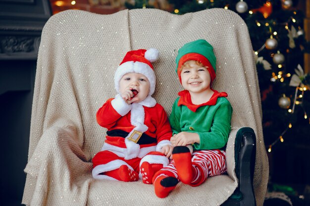 Cutte hermanitos en casa cerca de decoraciones navideñas