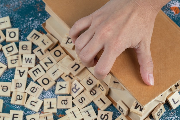 Dados de letras de madera sobre las páginas de un libro.