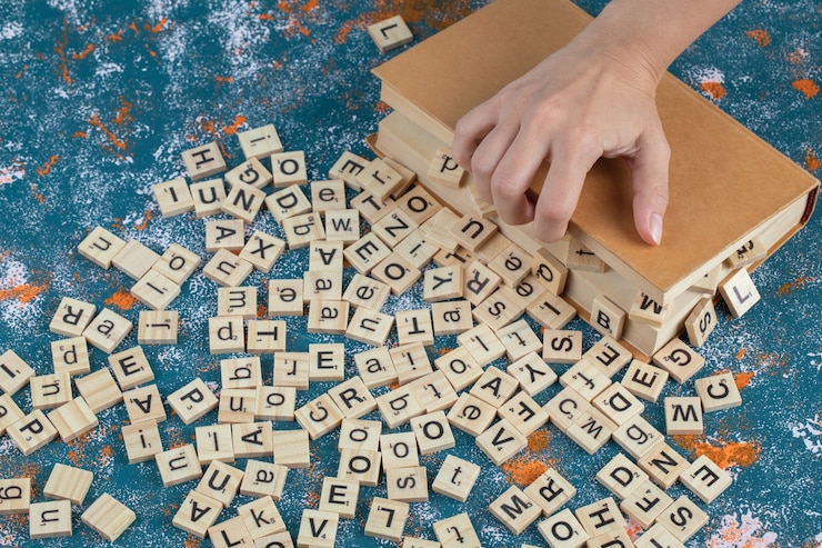 Foto gratuito dados de madera con letras impresas entre las páginas del libro.