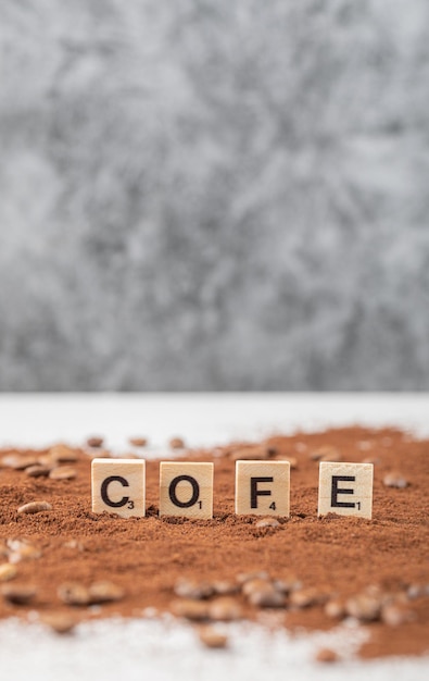 Foto gratuita dados de madera sobre café en polvo mezclado.