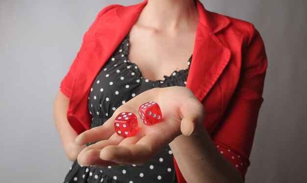 Dados rojos en manos de una mujer con una chaqueta roja