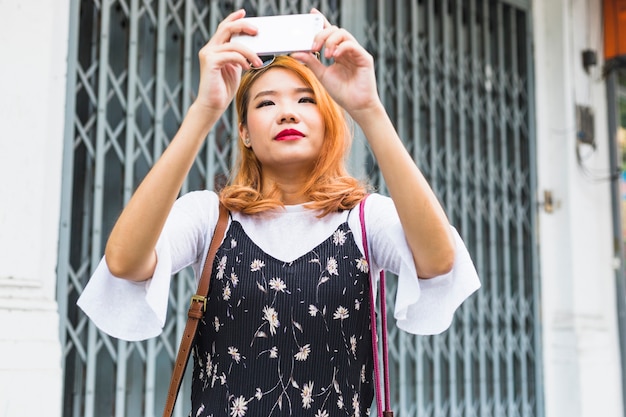 Foto gratuita dama atractiva disparando en el teléfono móvil