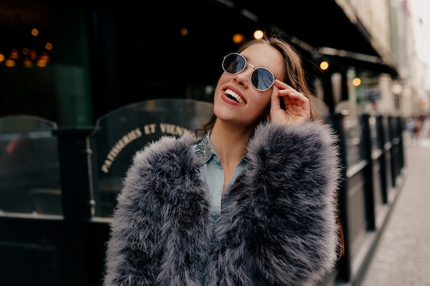 Dama con estilo salido en traje de moda en la ciudad. Retrato de moda mujer bonita en abrigo de piel