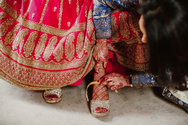Dama de honor ayuda a usar zapatos novia india