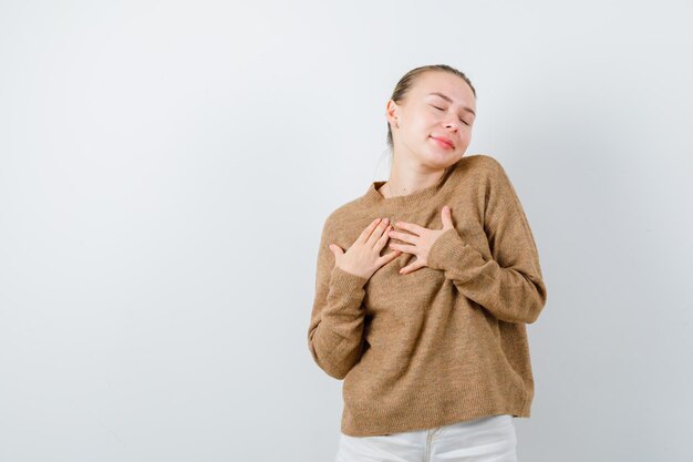 La dama rubia muestra un gesto de satisfacción en el fondo blanco