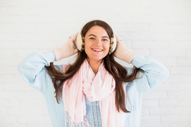 Foto gratuita dama sonriente en mitones, orejeras y bufanda.