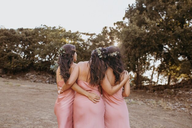 Damas de honor en bonitos vestidos celebrando la boda al aire libre