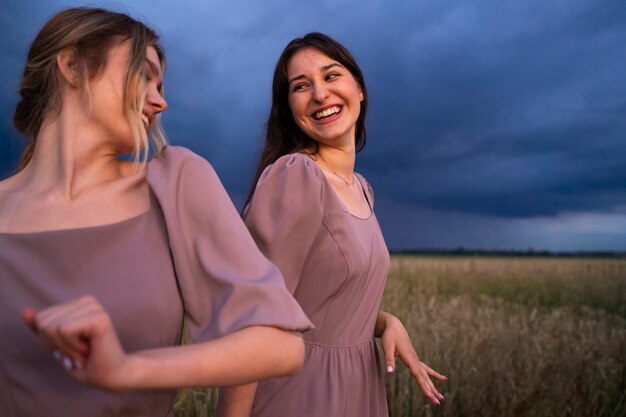 Damas de honor sonrientes de tiro medio al aire libre