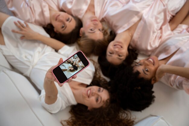 Damas de honor sonrientes de tiro medio tomando selfie