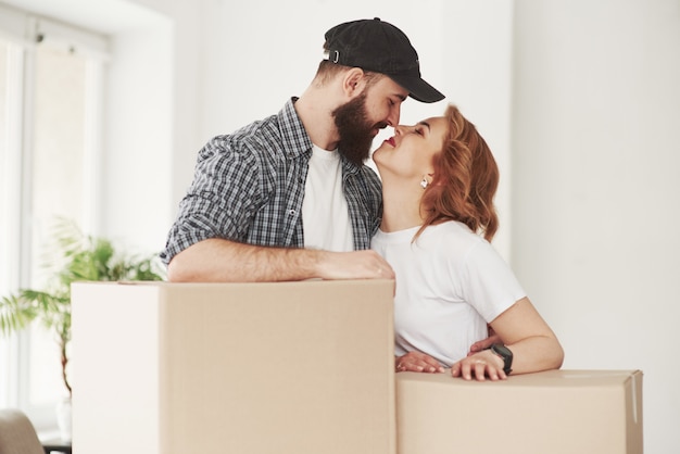 Dame un beso. Pareja feliz juntos en su nueva casa. Concepción de mudanza